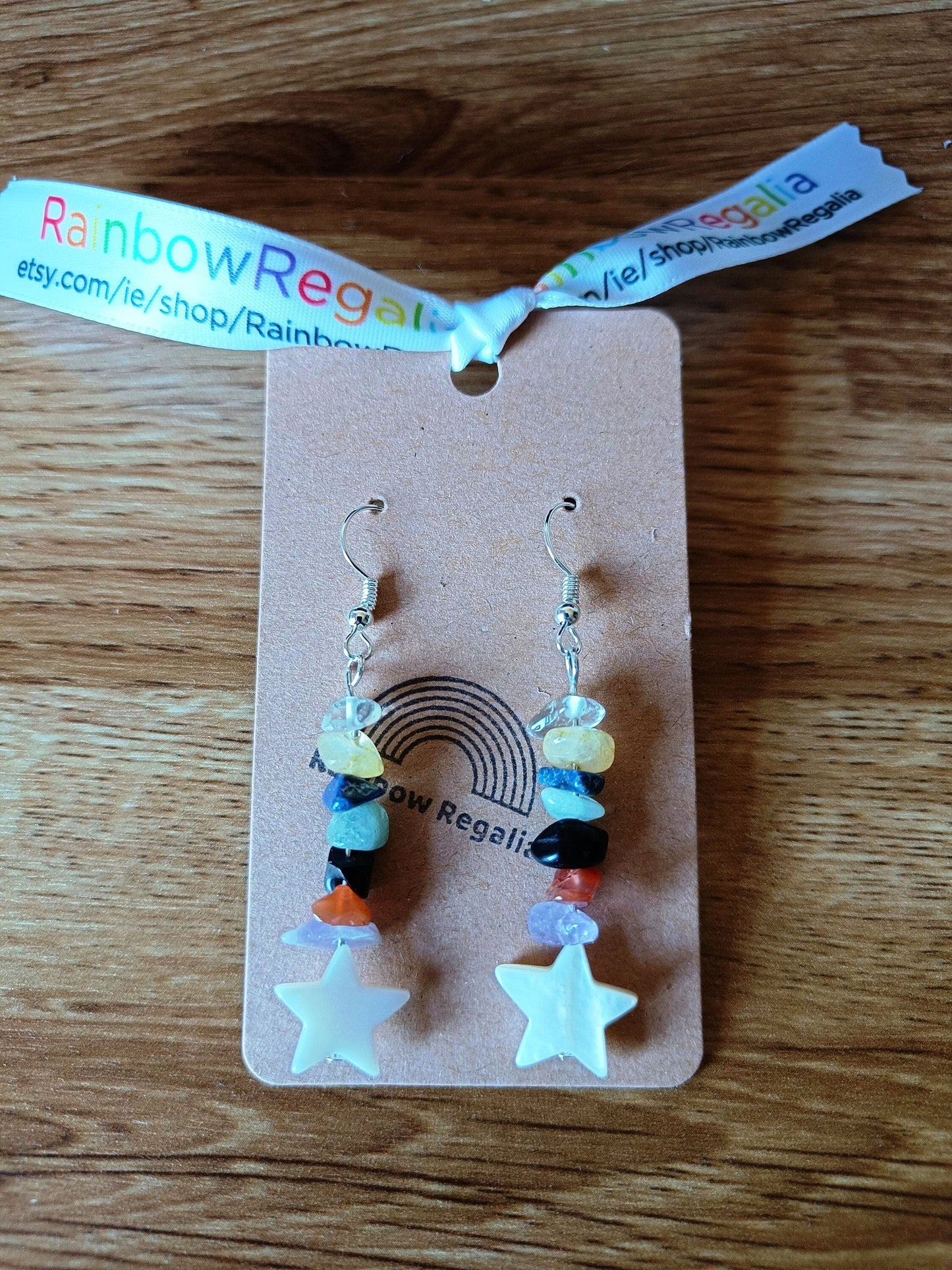 Multicoloured star earrings with repurposed glass and gemstone chips, adorned with white star-shaped shell charms.