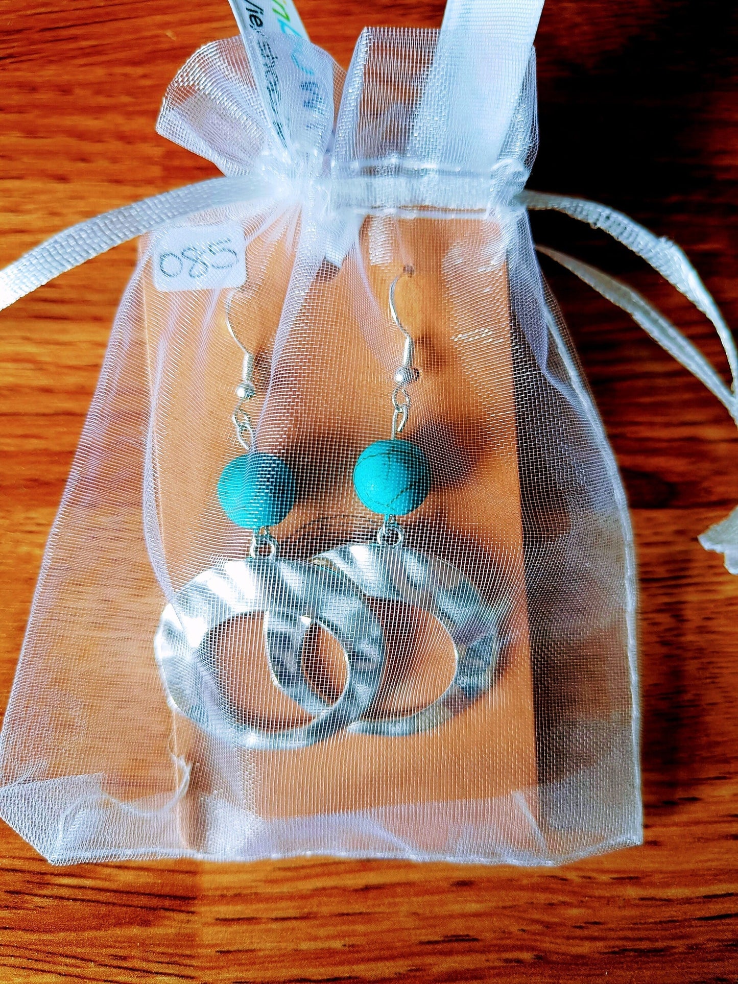 Turquoise hoop earrings with repurposed beads and antique silver hoops in a sheer gift bag.