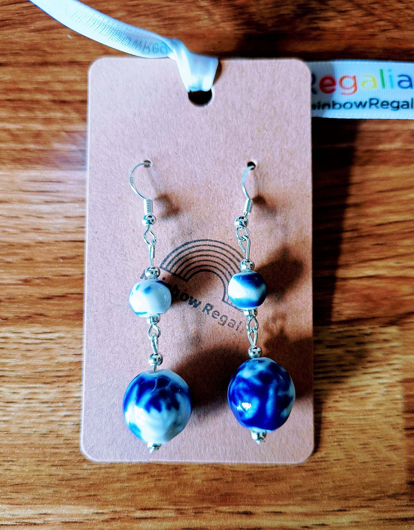 Blue and white ceramic earrings with Delft pottery design on card.