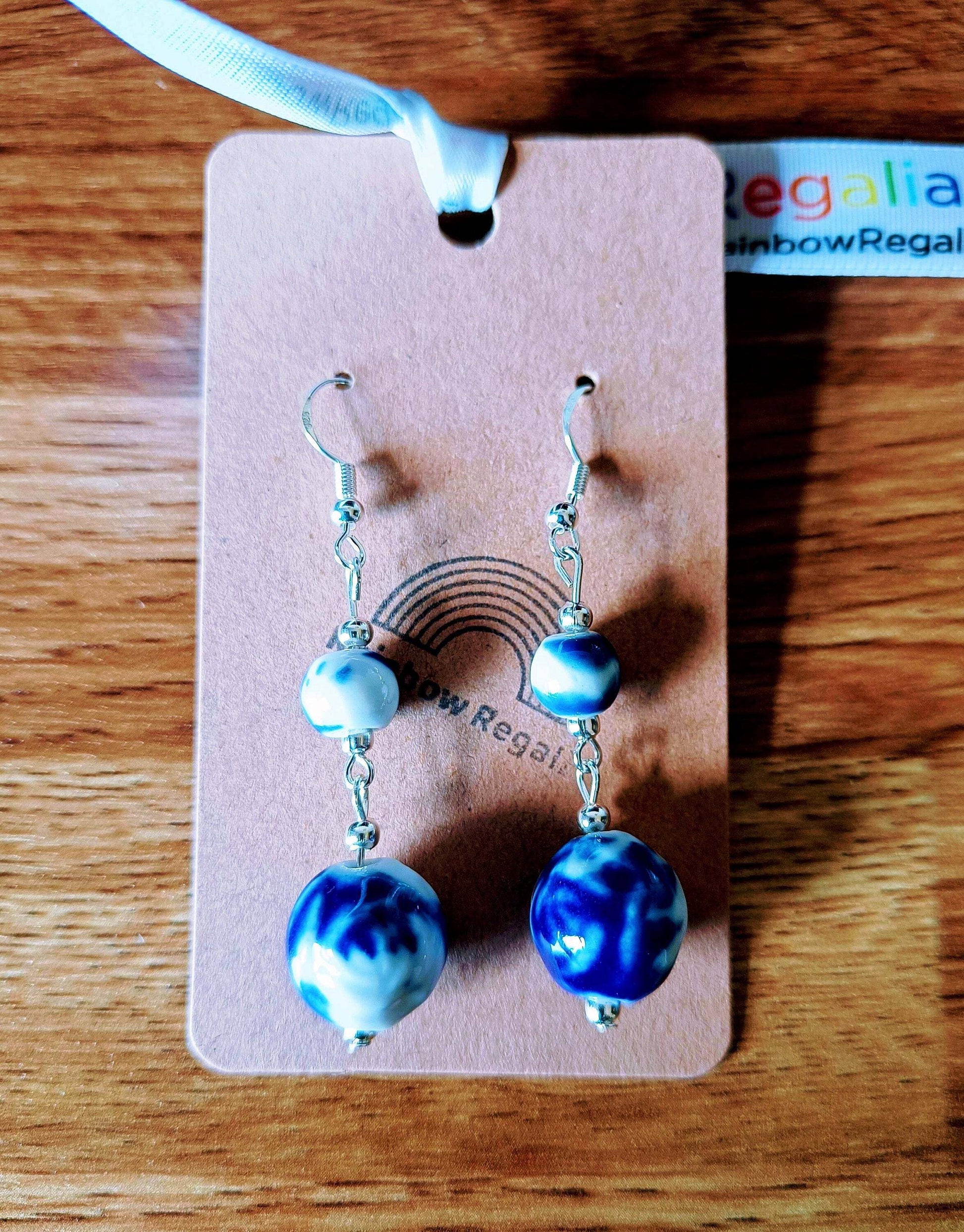 Blue and white ceramic earrings with Delft pottery design on card.