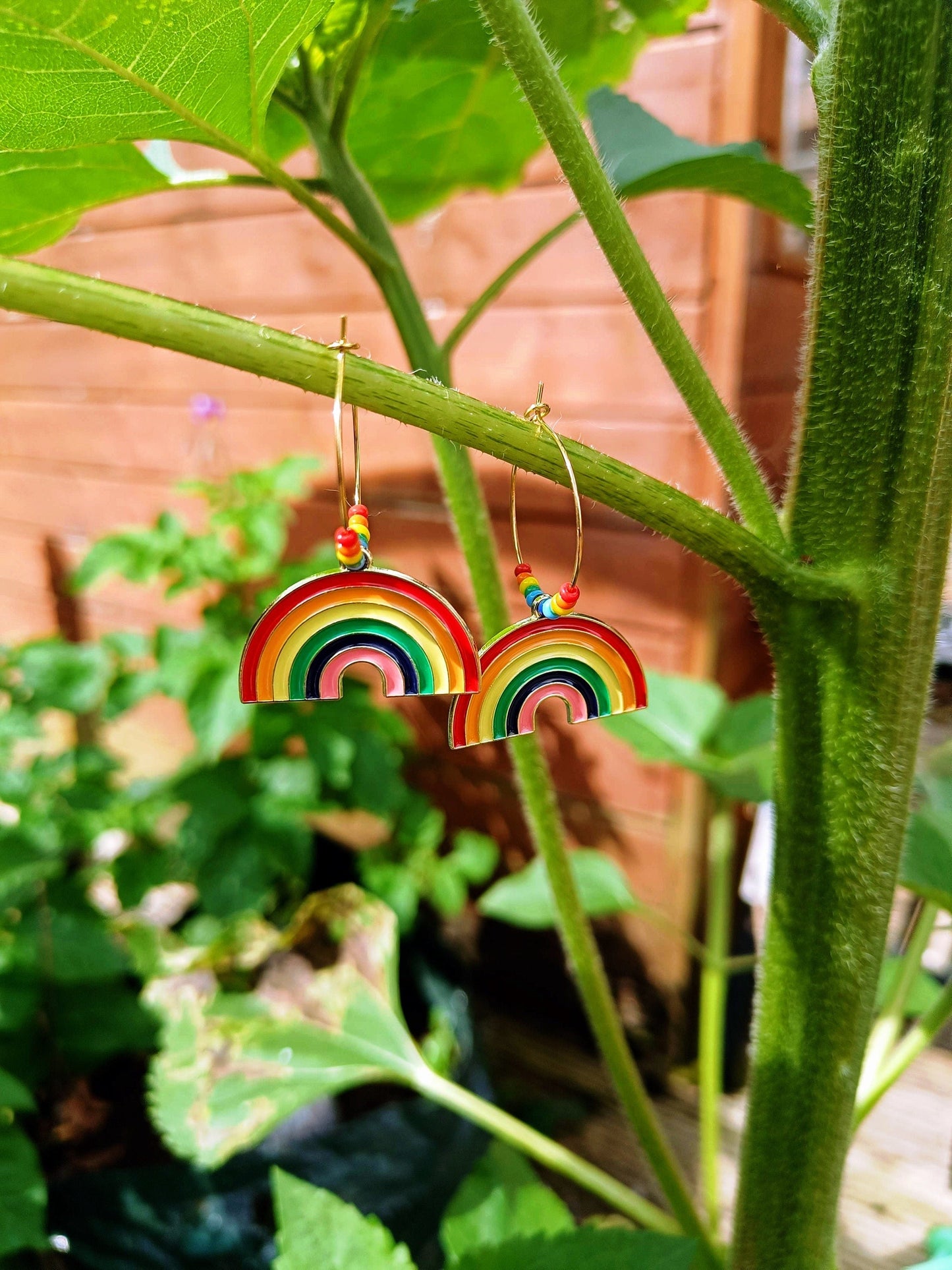 Rainbow Hoops earrings with colorful enamel rainbows and repurposed glass seed beads on gold-colored brass hoops.