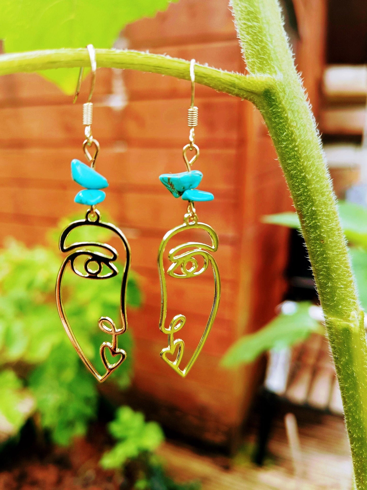 Turquoise abstract face earrings with repurposed turquoise chips and antique gold plate, hanging from 14K gold plated ear wires.