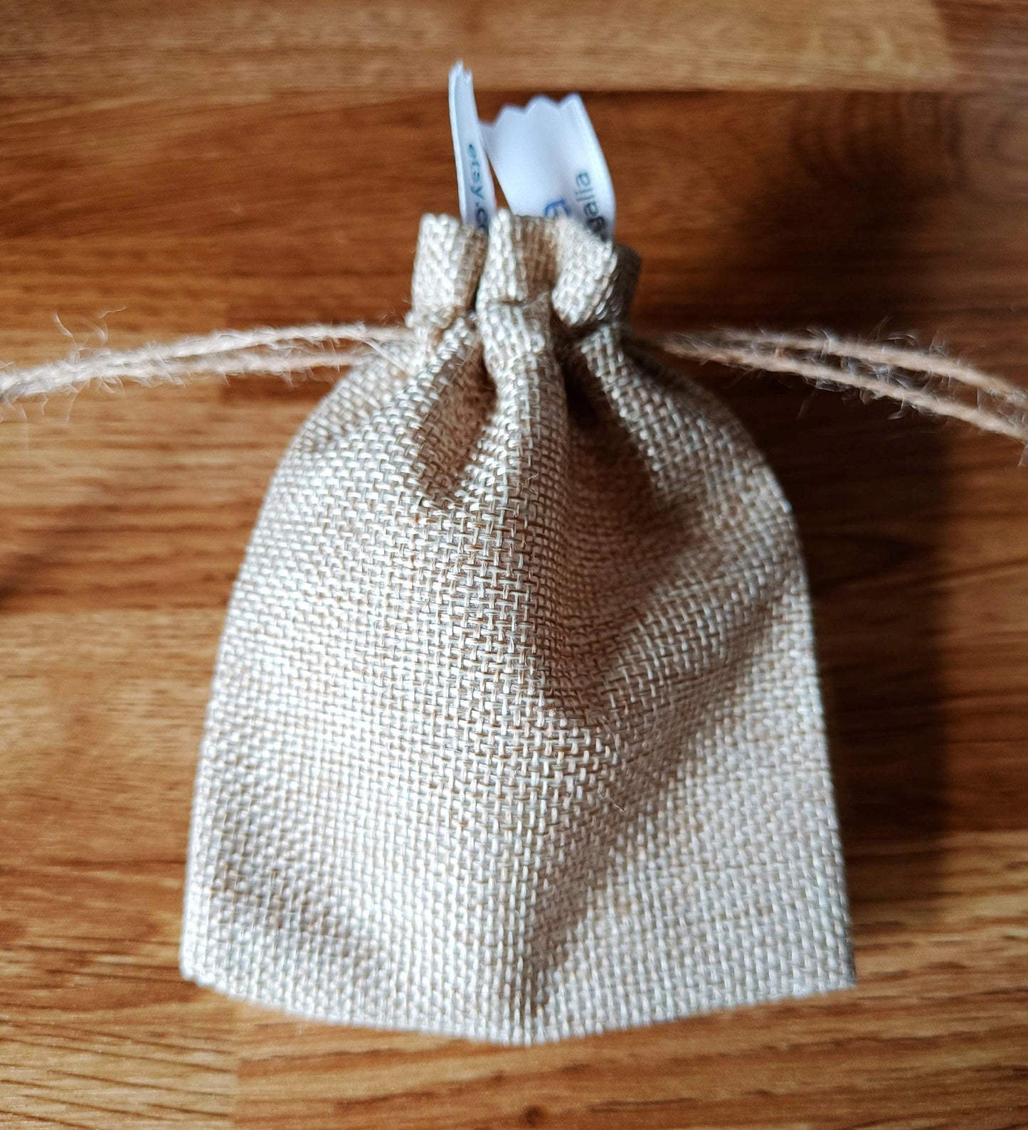 Jasmine Drop Earrings in burlap gift pouch showcasing eco-friendly packaging.
