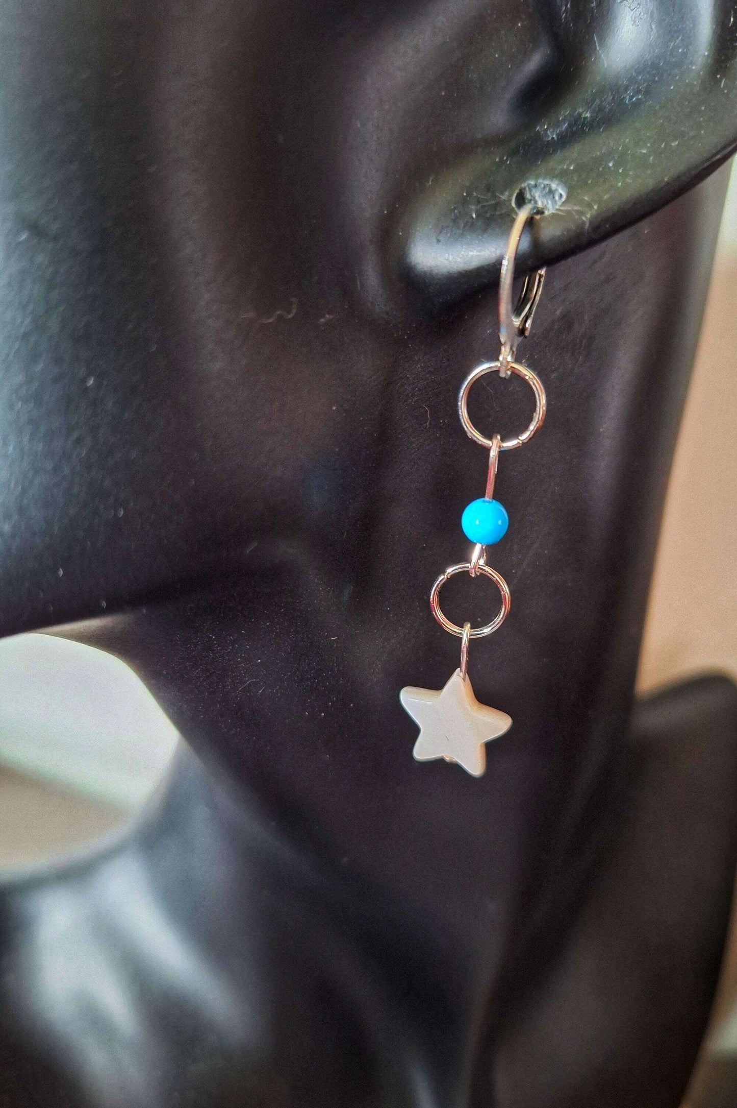 Cali Turquoise Star Earrings with mother of pearl star-shaped bead, turquoise stone, on stainless steel huggie hoop.