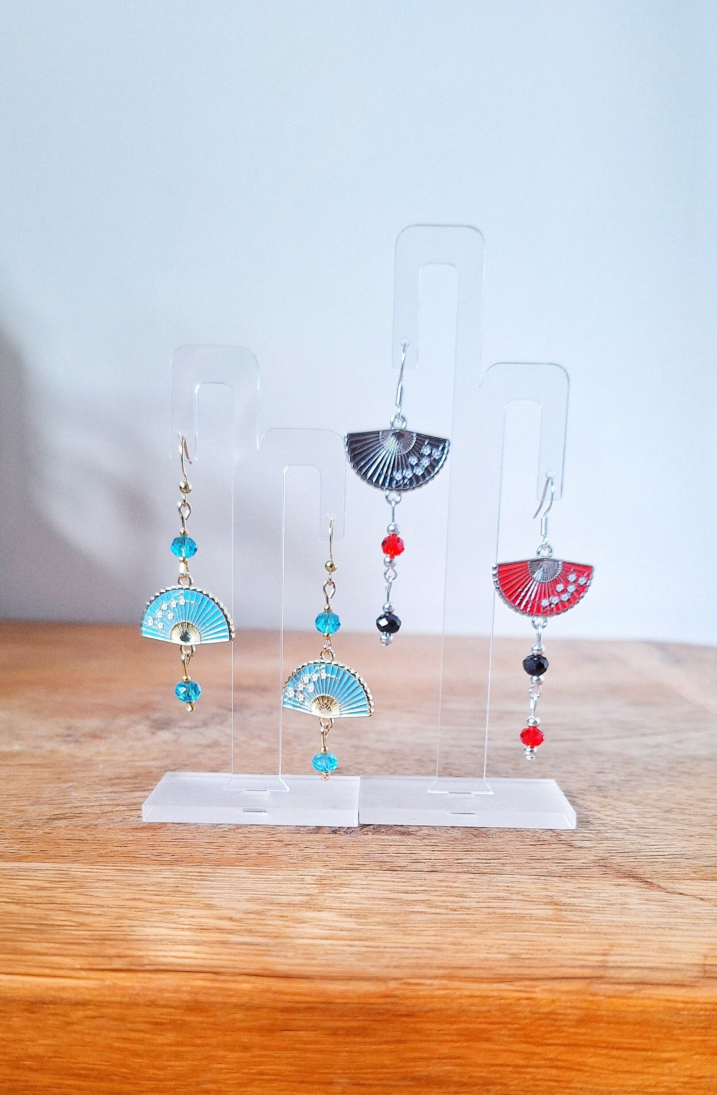Fumika Fan Earrings with faceted glass beads and fan charms displayed on a stand.