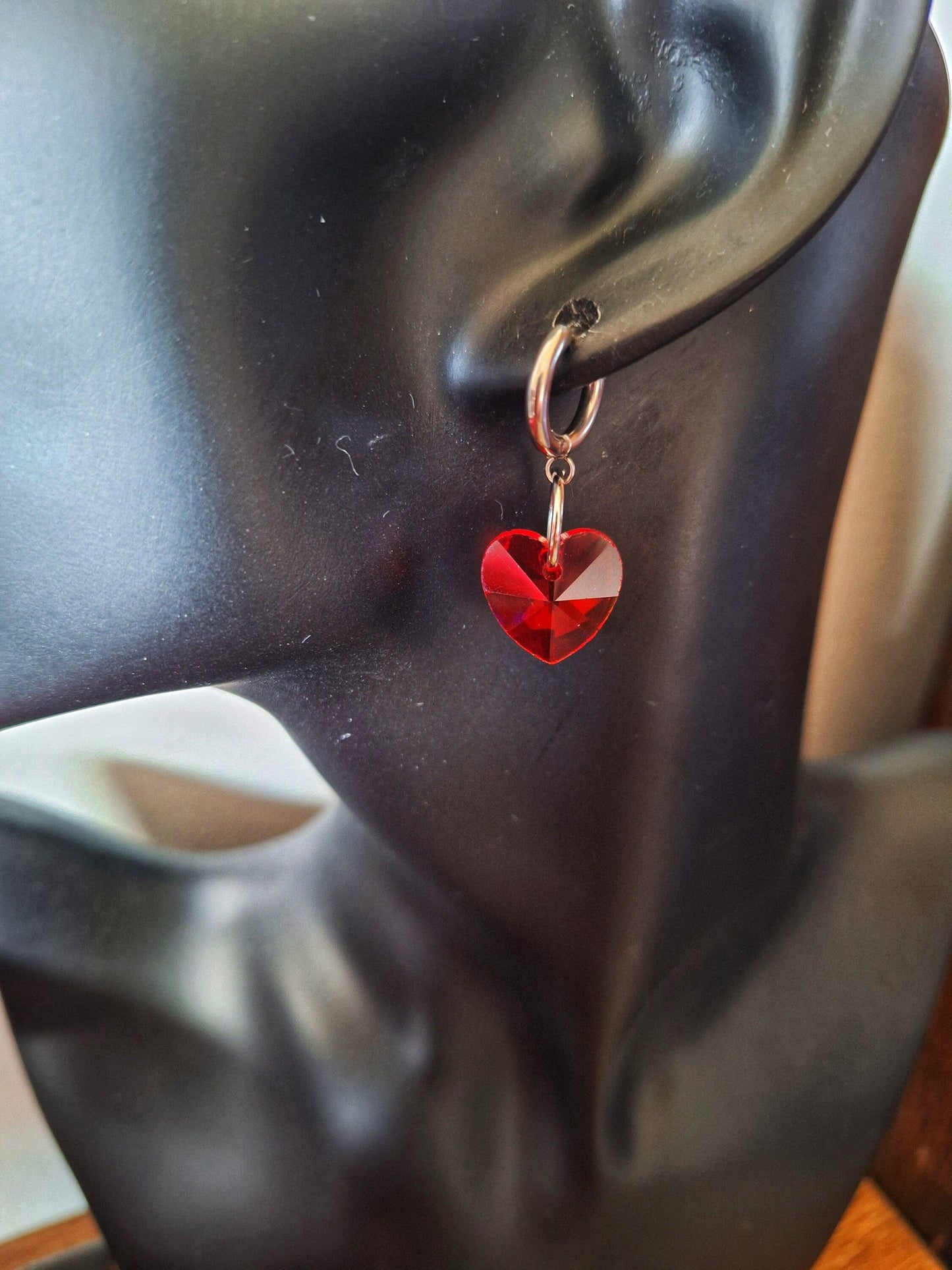 Venus Crystal Heart Huggies with red faceted glass heart bead on stainless steel hoop earring.