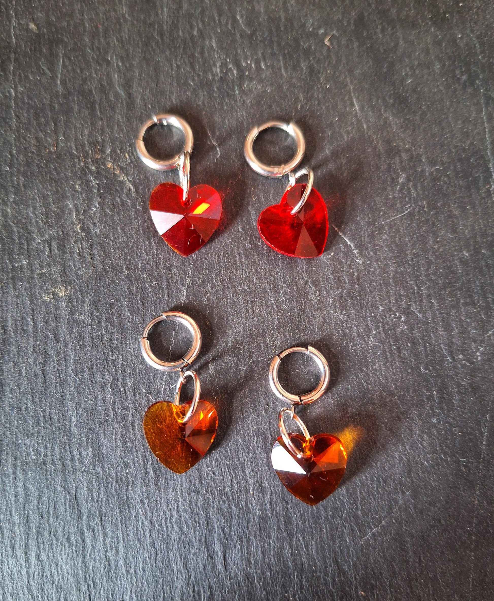 Venus Crystal Heart Huggies with red and amber faceted glass heart beads on stainless steel hoops.