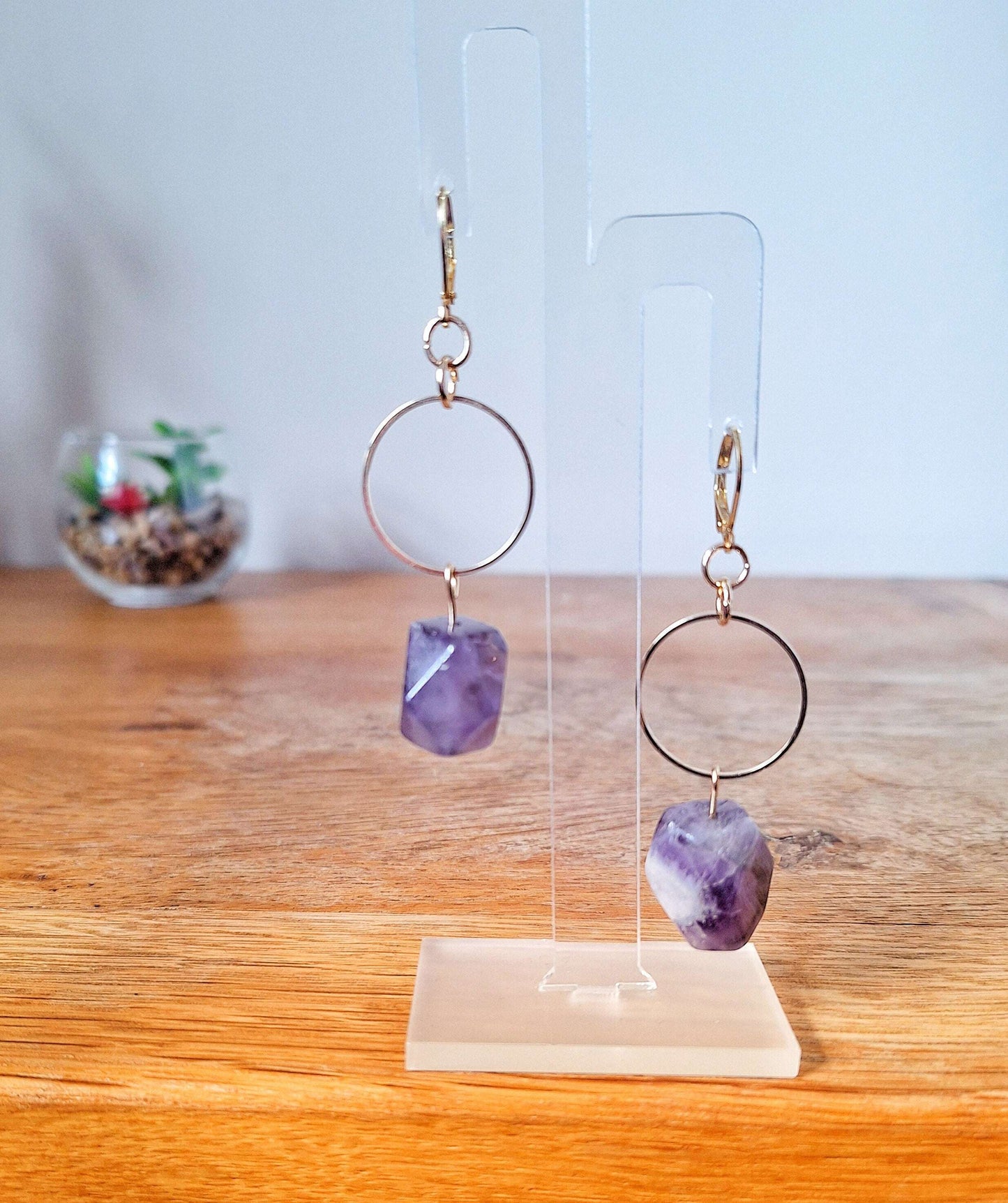 Florence Amethyst Earrings with raw amethyst stones and gold-plated lever back ear wires on a display stand.