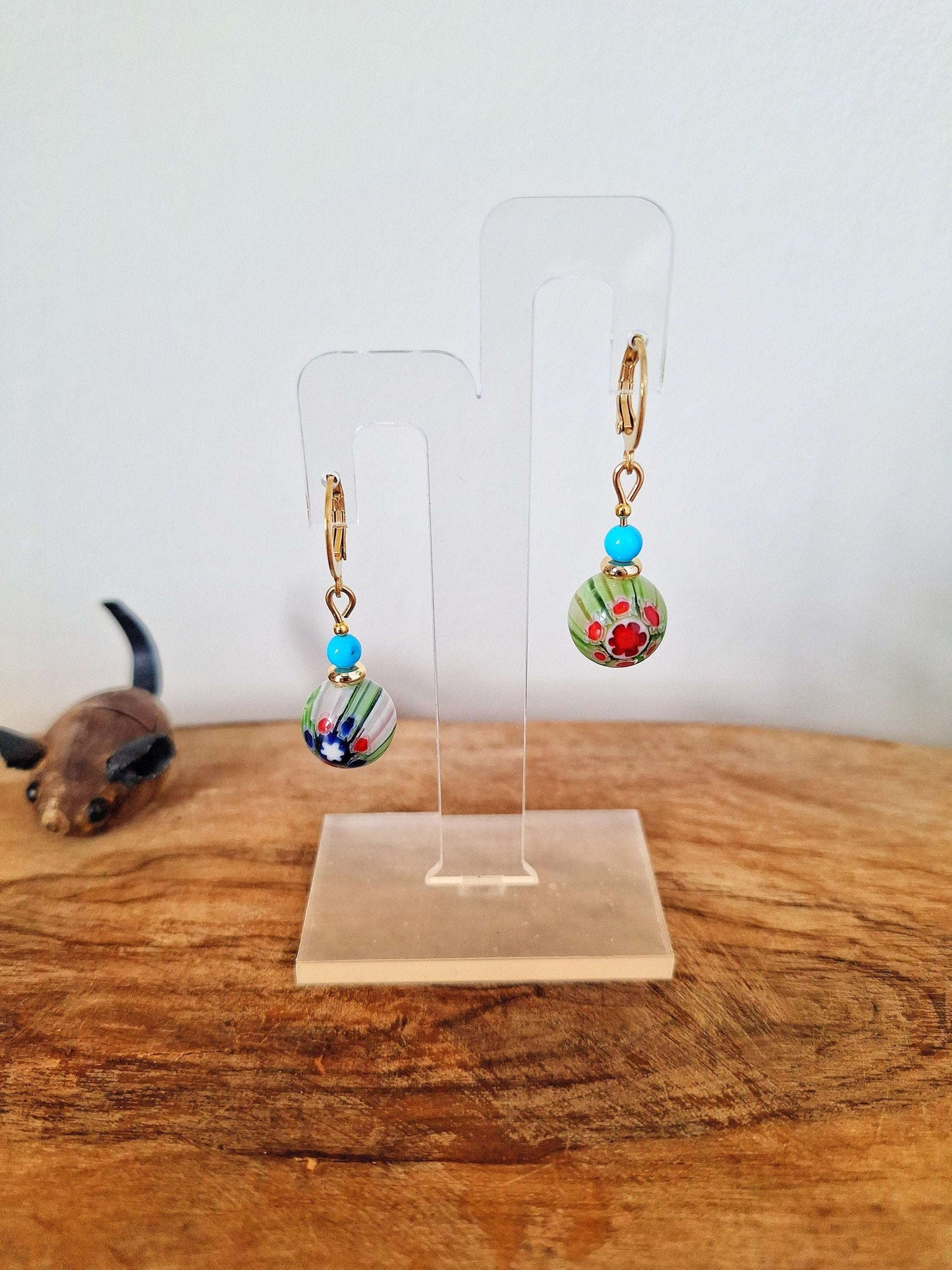 Millefiori Glass Bead Huggies with gold-plated findings on display stand.