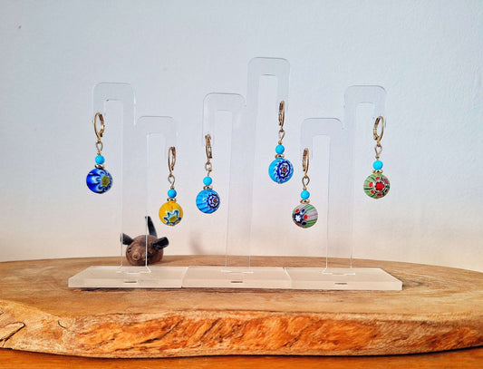 Millefiori Glass Bead Huggies with gold-plated accents on display stands.