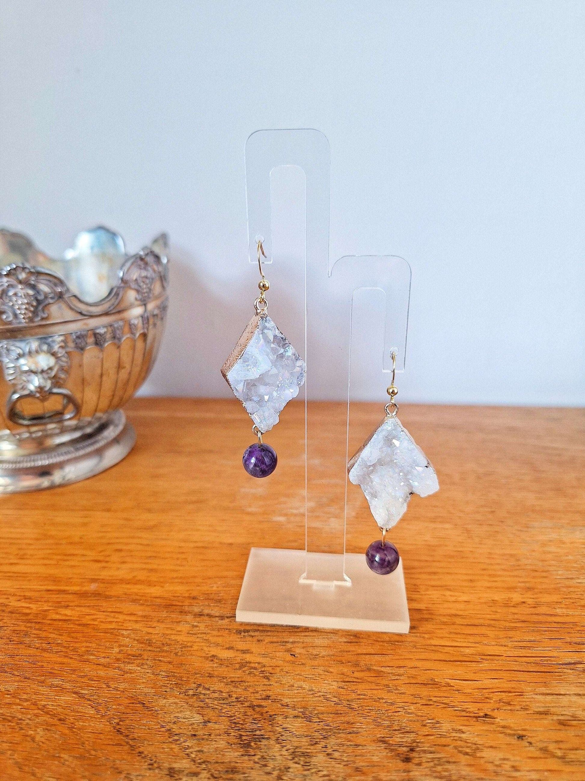 Aphrodite Quartz and Amethyst Earrings with gold-plated accents on display stand.