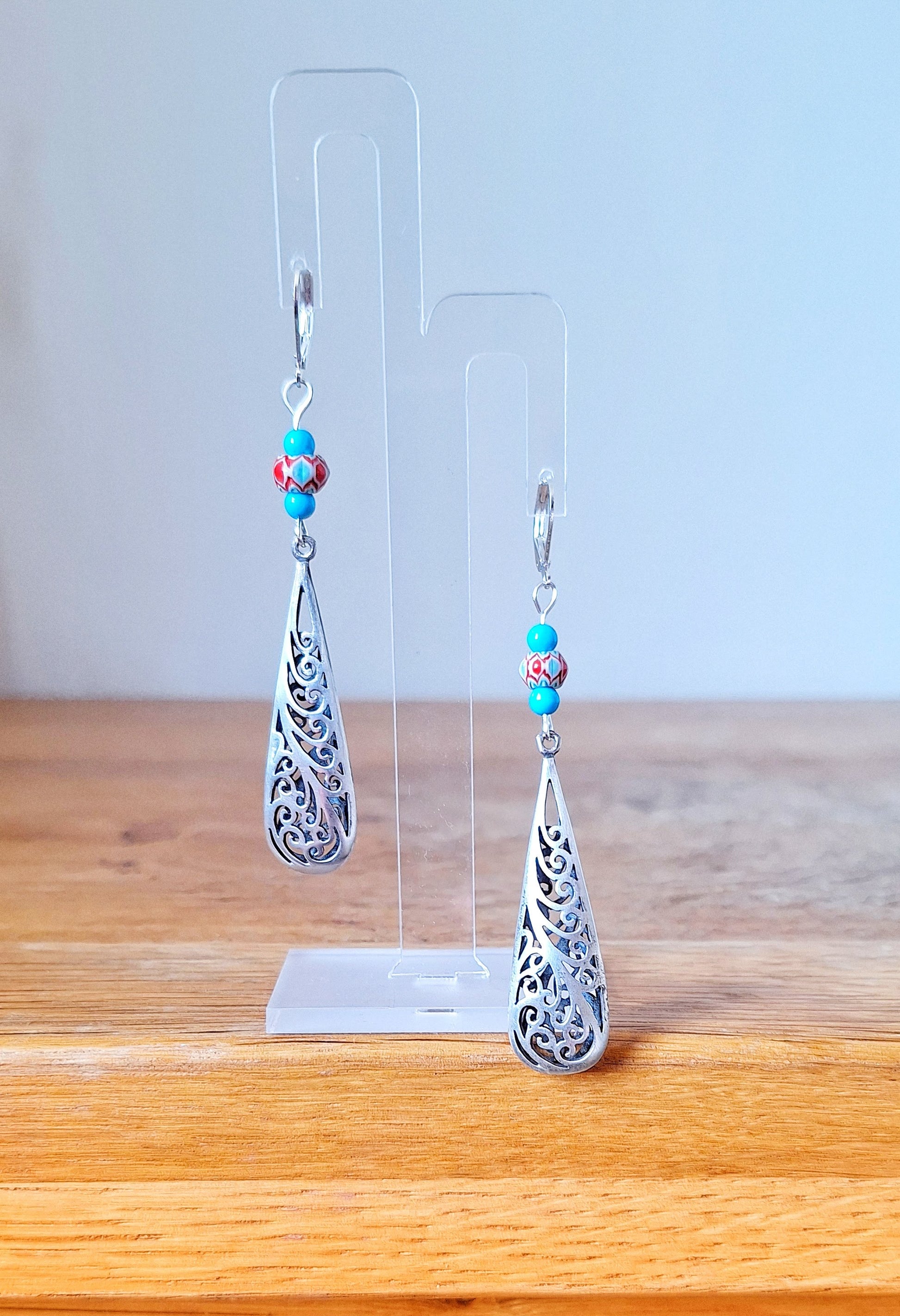 Long, elegant, 80mm drop silver earrings. Made with repurposed turquoise stone and glass beads with silver toned teardrop. Sterling silver lever back ear wires.