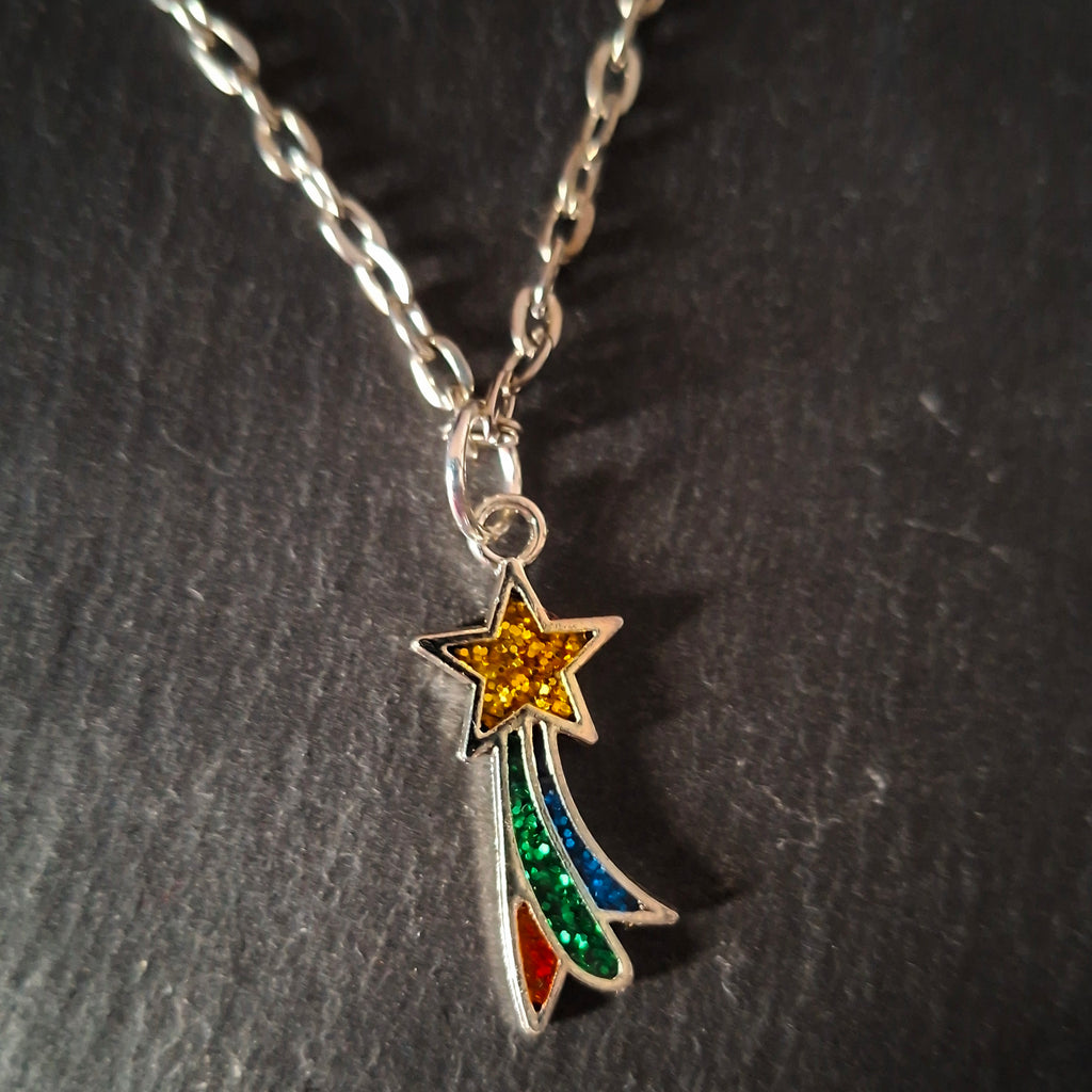 Necklace with a shooting star-shaped pendant on a dark textured surface