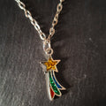 Necklace with a shooting star-shaped pendant on a dark textured surface