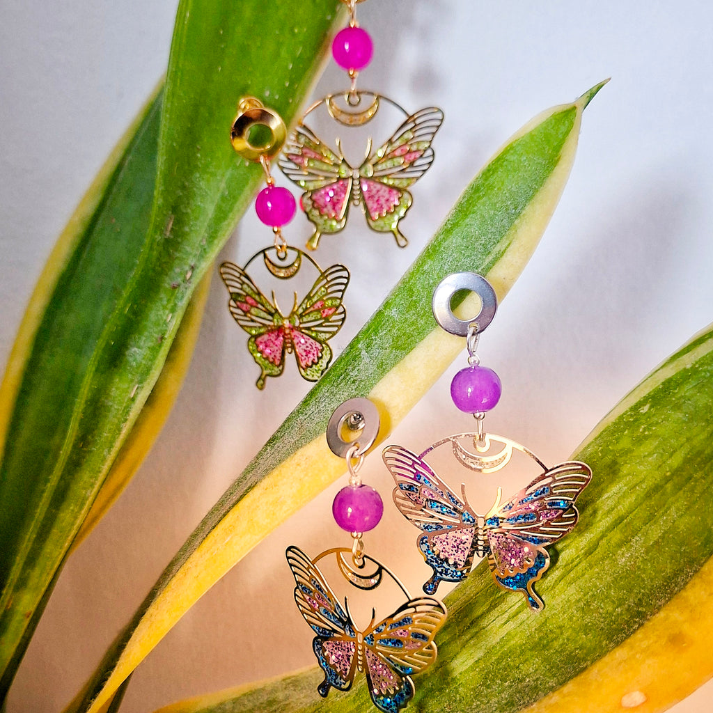 Butterfly-shaped earrings with colorful beads on a leaf background