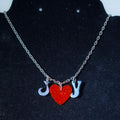 Necklace with heart and letter charms on a dark background