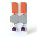 Earrings with orange and gray geometric pendants and purple beads. Handmade using bio-resin and repurposed glass beads by RainbowRegalia, Greystones, Co. Wicklow.