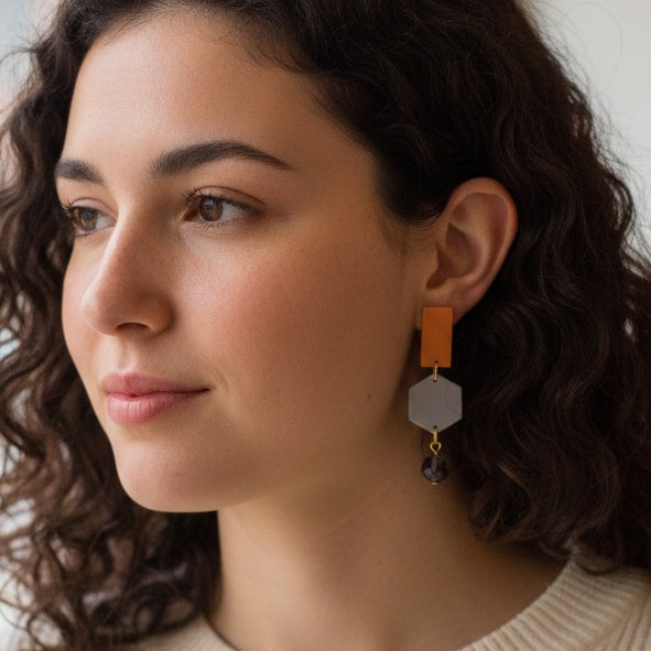 Earrings with orange and gray geometric pendants and purple beads. Handmade using bio-resin and repurposed glass beads by RainbowRegalia, Greystones, Co. Wicklow.