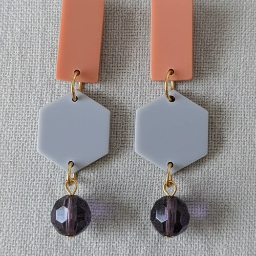 Earrings with orange and gray geometric pendants and purple beads. Handmade using bio-resin and repurposed glass beads by RainbowRegalia, Greystones, Co. Wicklow.