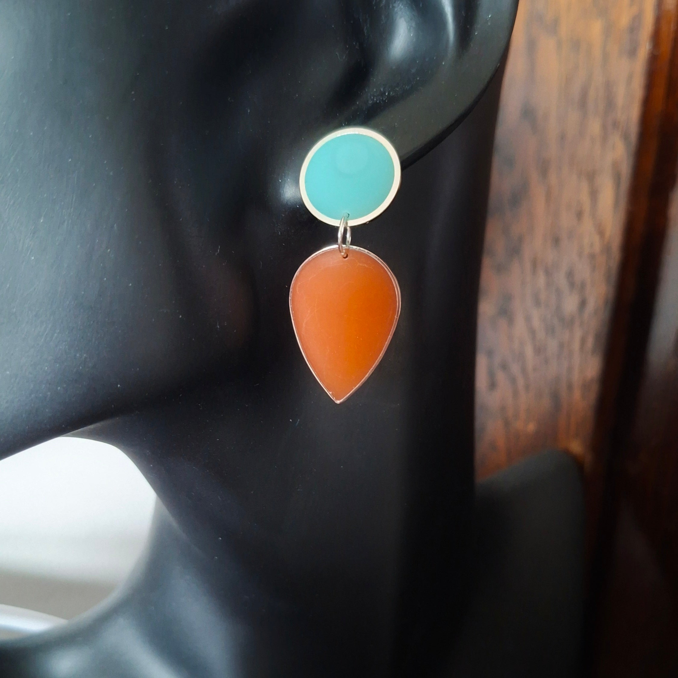 Pair of earrings with turquoise and orange teardrop shapes. Gold or silver finish.