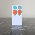 Pair of earrings with turquoise and orange teardrop shapes. Gold or silver finish.