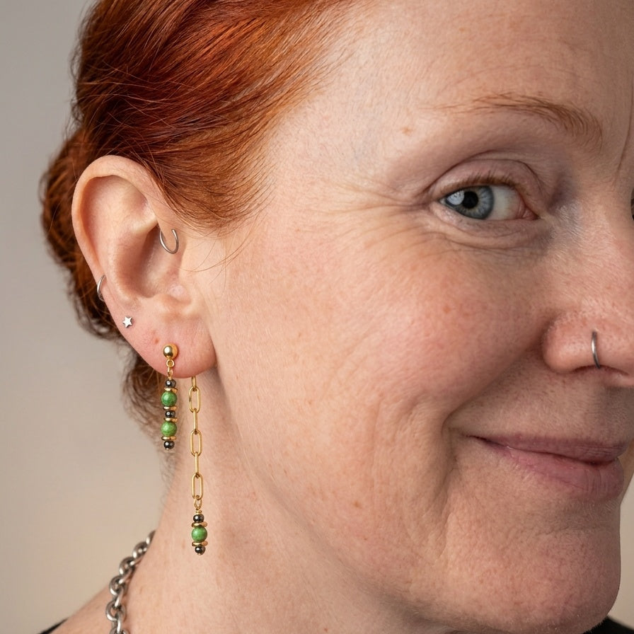 Gold-plated earrings with green glass beads and hematite.