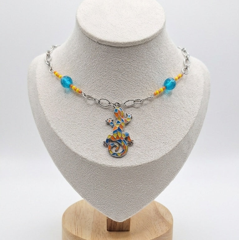 A vibrant bohemian statement piece made from repurposed beads and a mosaic lizard pendant.