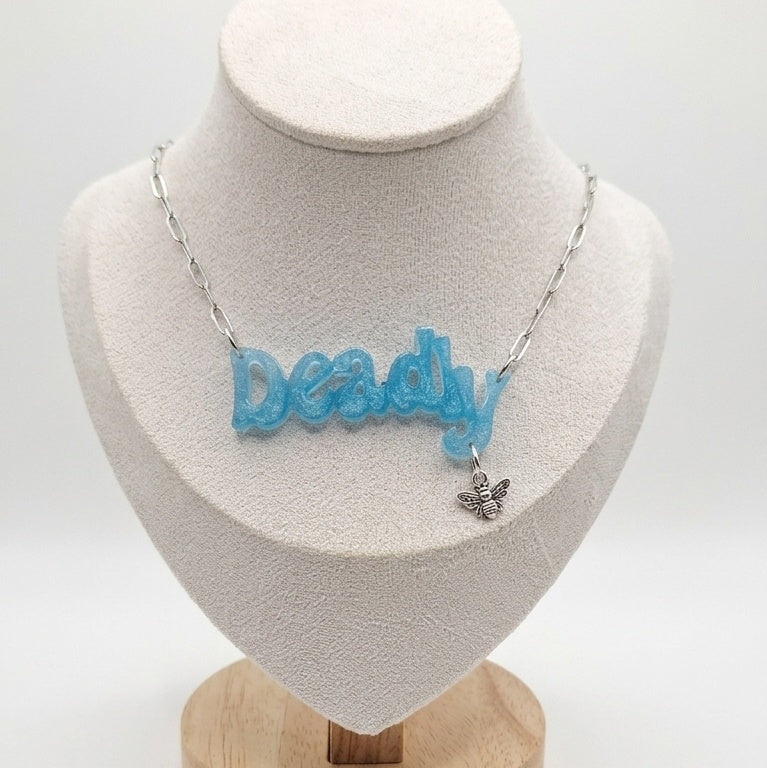Necklace with Deadly written in blue with bee charm.