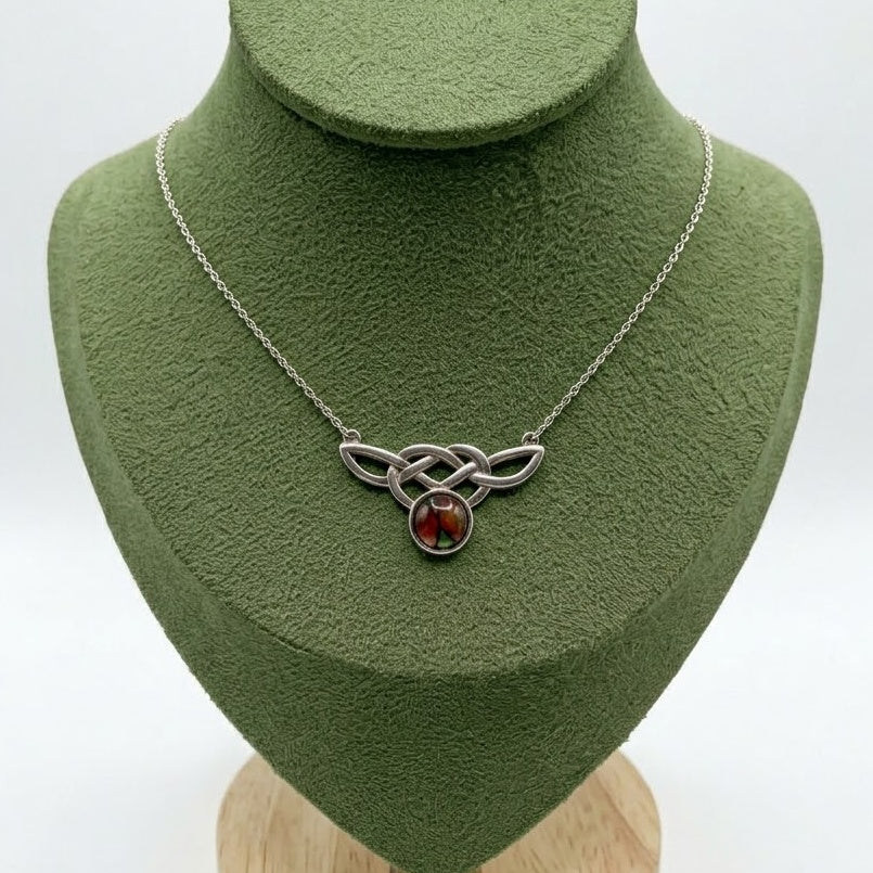 Scottish Heathergems necklace with sterling silver Celtic knotwork and a round red-and-green heather cabochon on a silver chain.