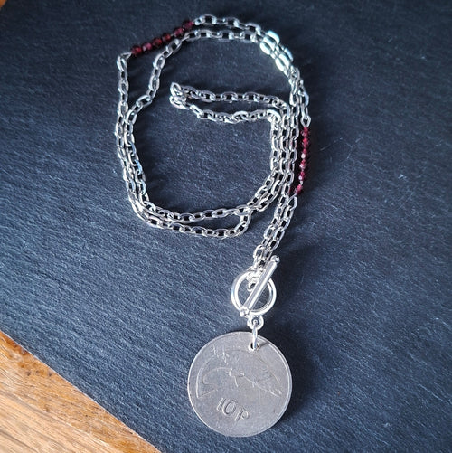 A necklace made using a genuine 1976 Irish 10p coin, repurposed garnet beads and suspended from a stainless steel chain. By RainbowRegalia, Greystones, Co Wicklow.