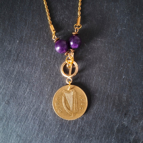 Necklace made with genuine Irish 1986 20p coin and repurposed amethyst beads. Suspended from gold-plated chain.
