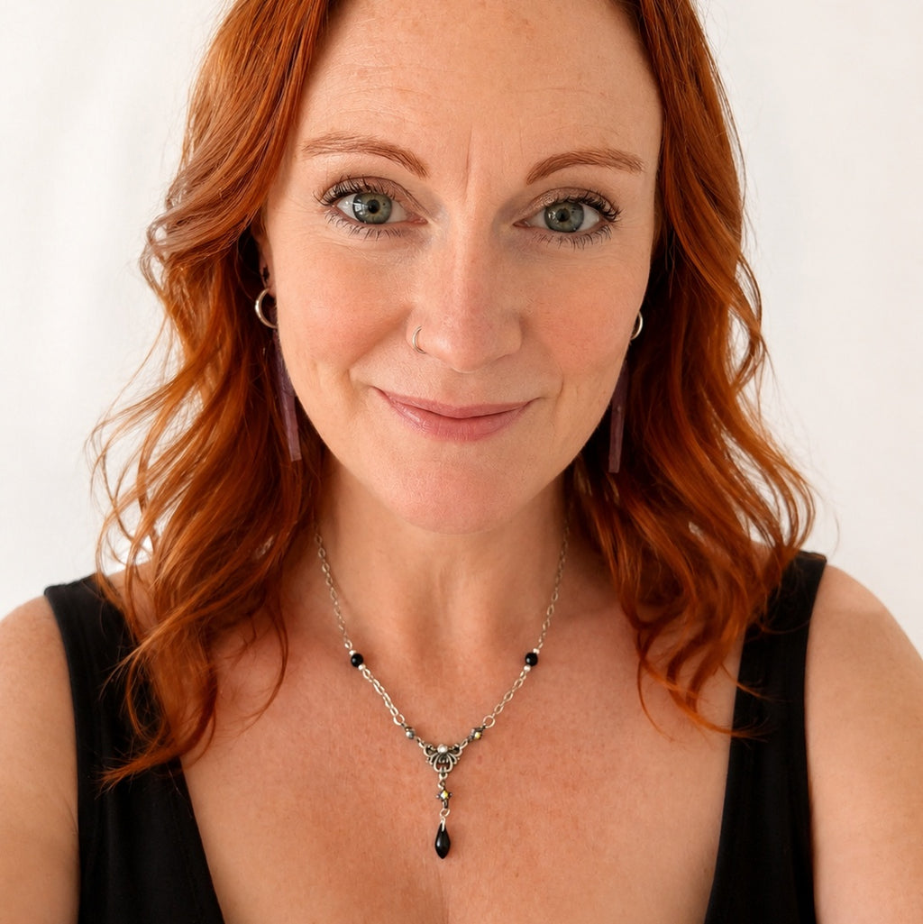Silver coloured necklace made with black beads and vintage pieces
