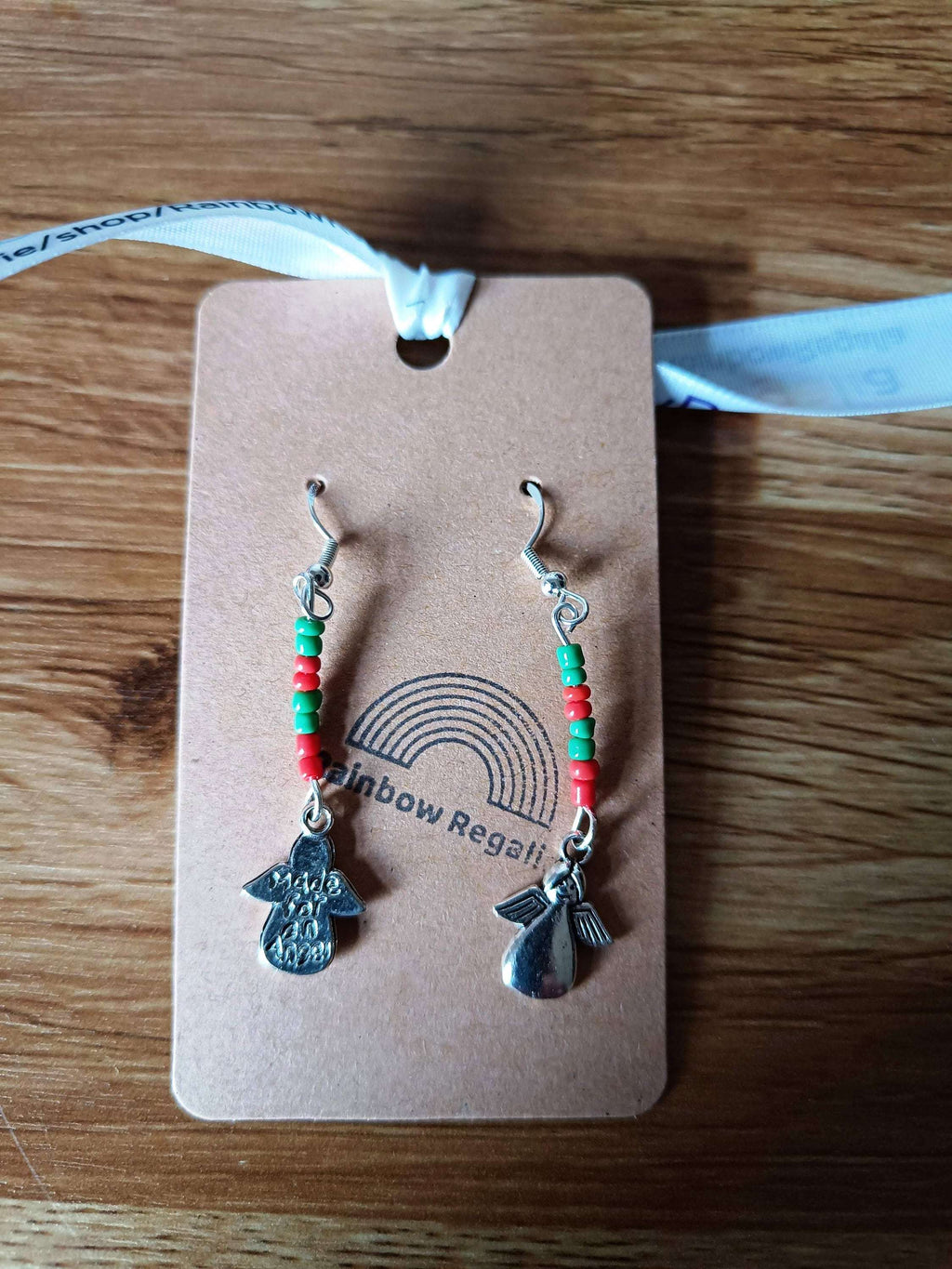 Red and Green Angel Earrings made from repurposed glass seed beads with silver accents displayed on a brown card.