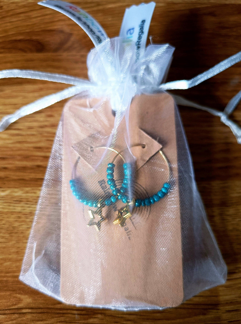 Teal Star Hoops with gold brass, teal ceramic beads, and gold star charm in gift pouch.