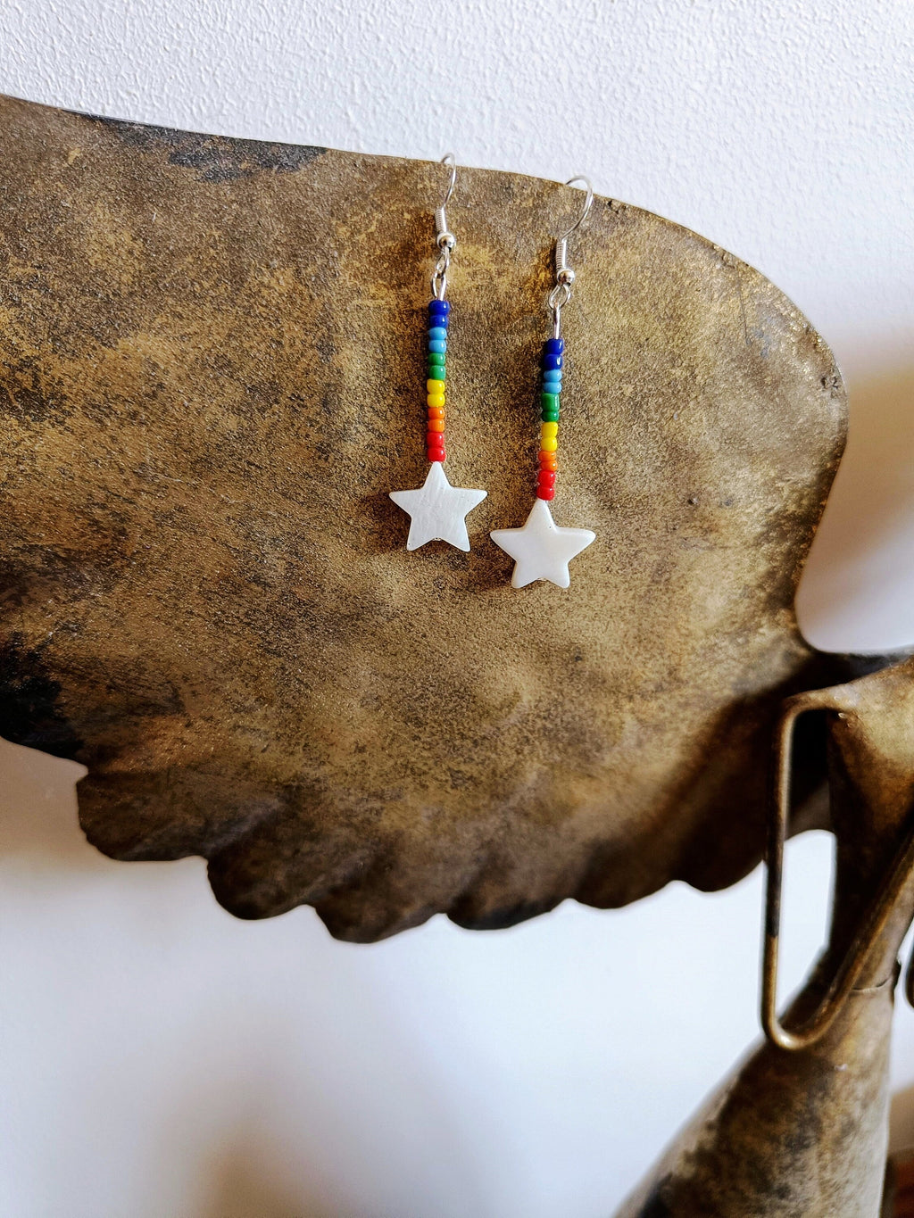 Rainbow Star Earrings with repurposed glass seed beads and white star-shaped shell.