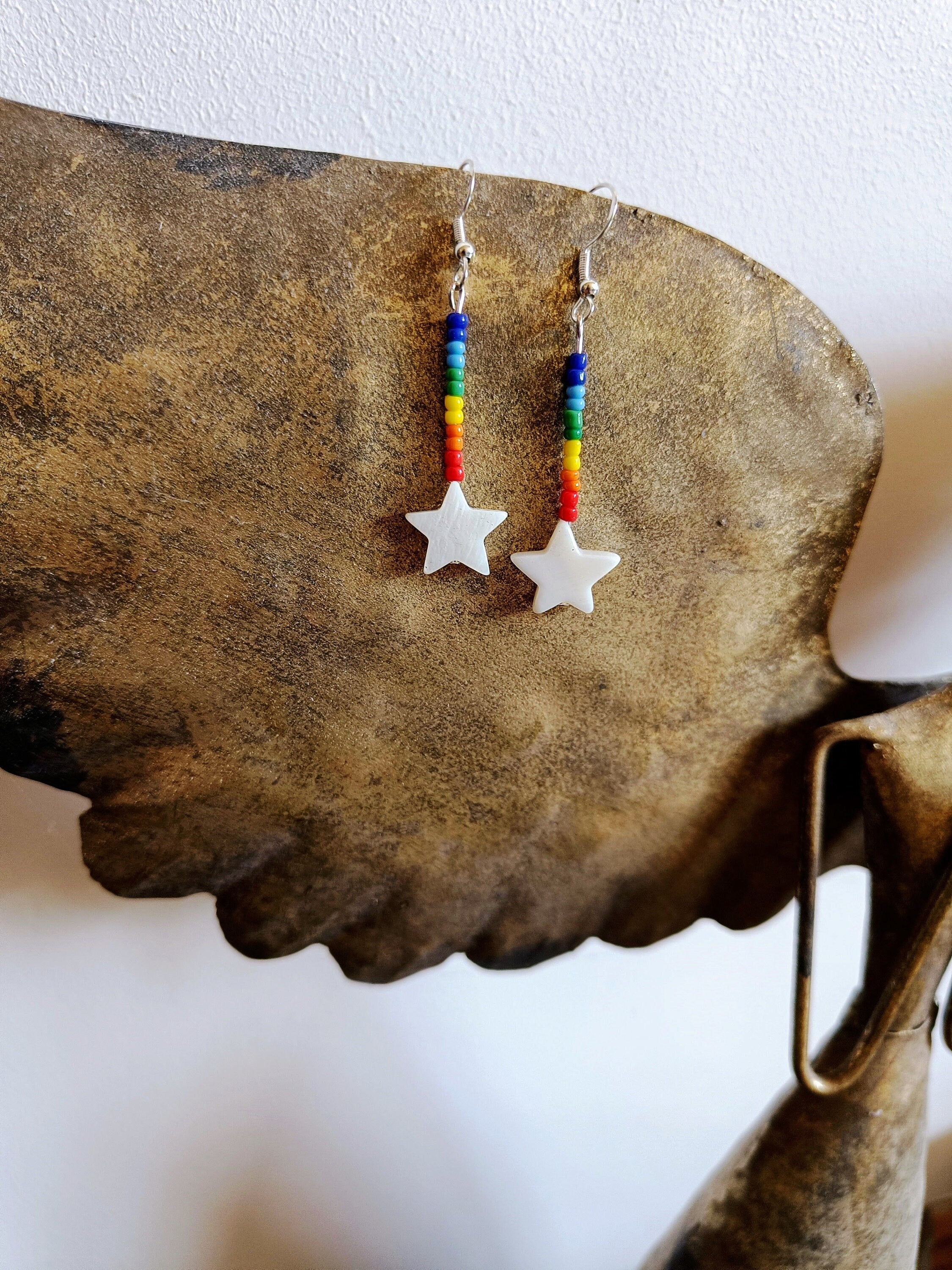 Rainbow Star Earrings with repurposed glass seed beads and white star-shaped shell.