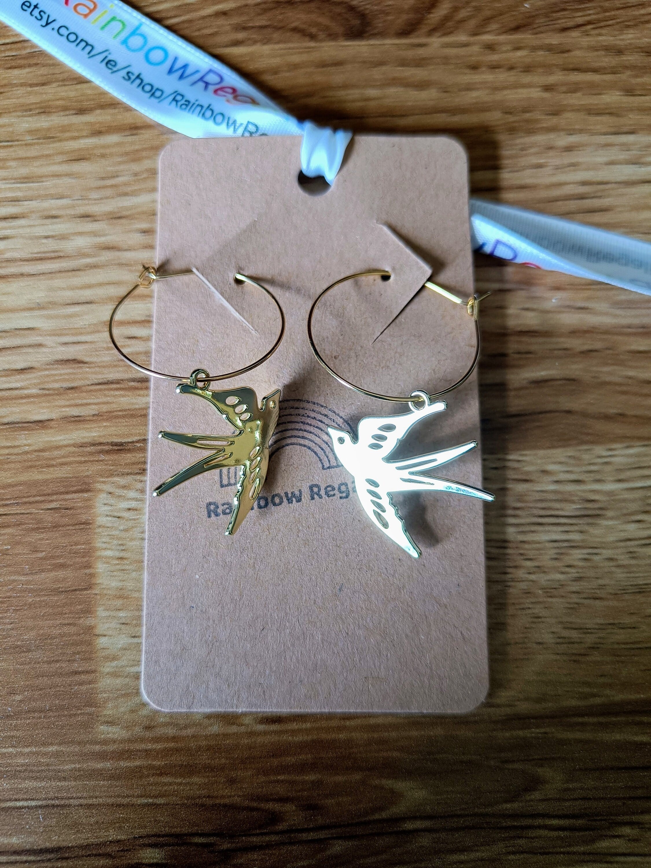Gold-plated swallow hoop earrings symbolizing good luck and positivity.