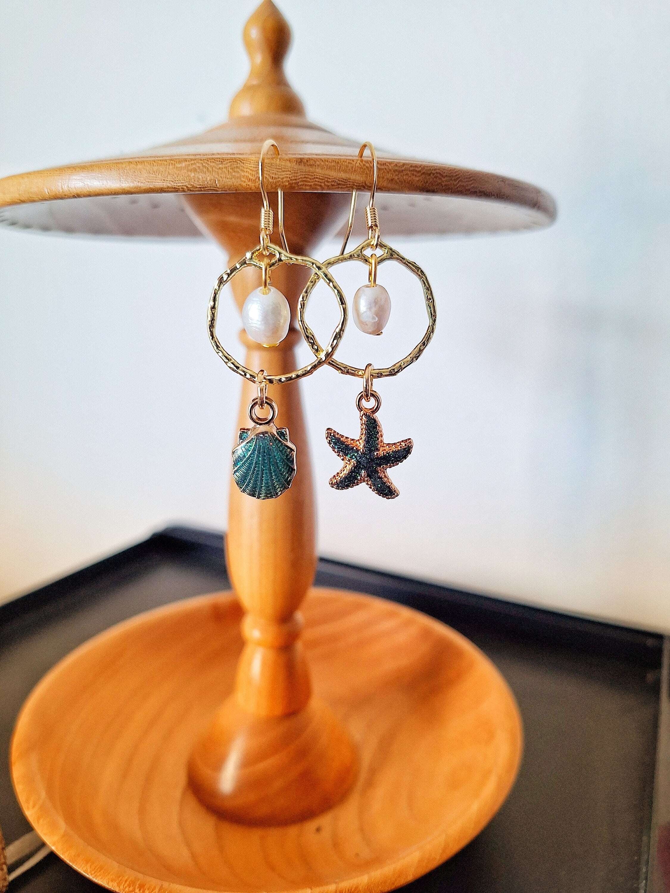 Mismatched shell and starfish earrings with gold, featuring pearls and coastal charm design.