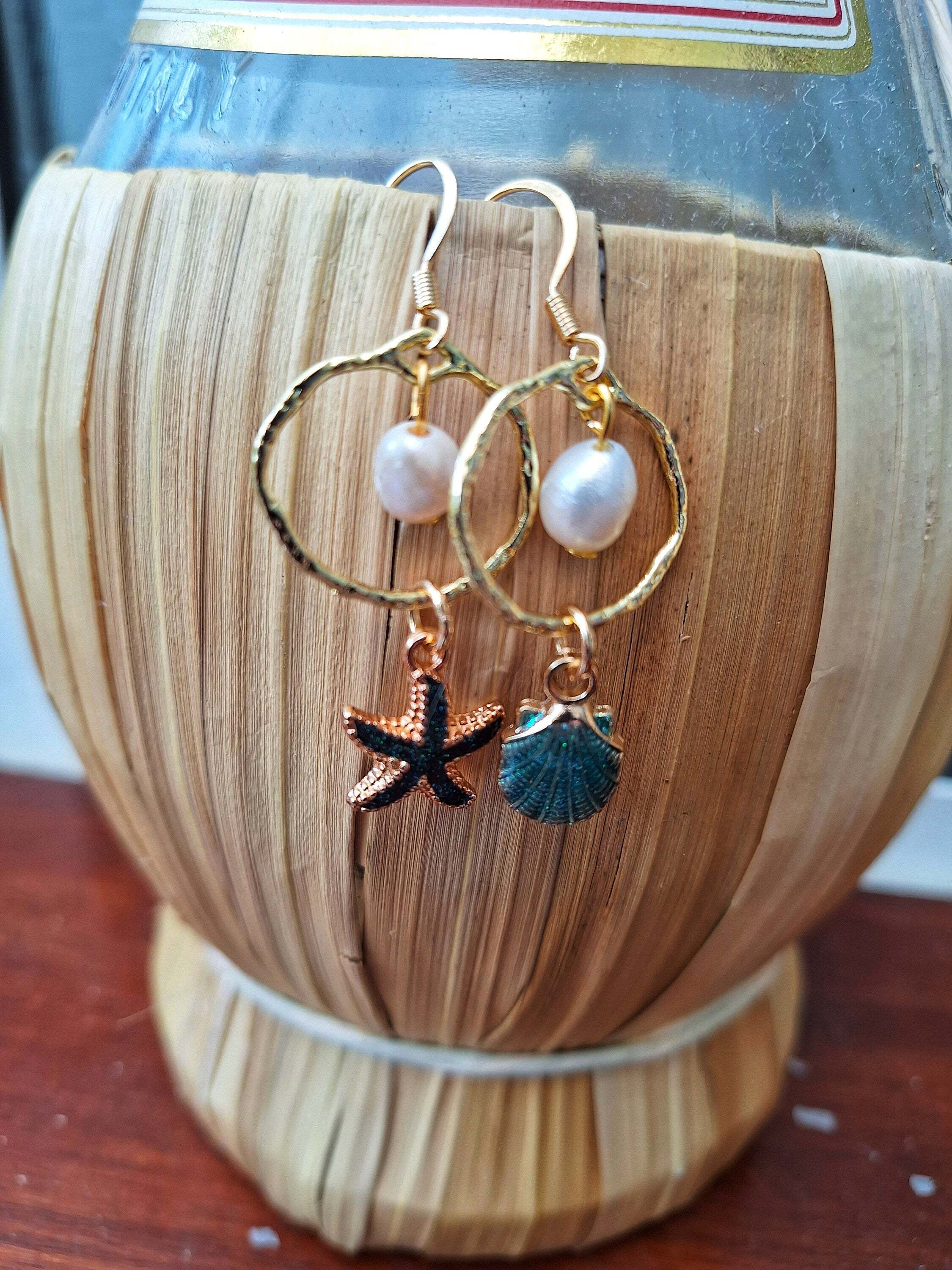 Mismatched shell and starfish earrings with gold detailing and freshwater pearls.