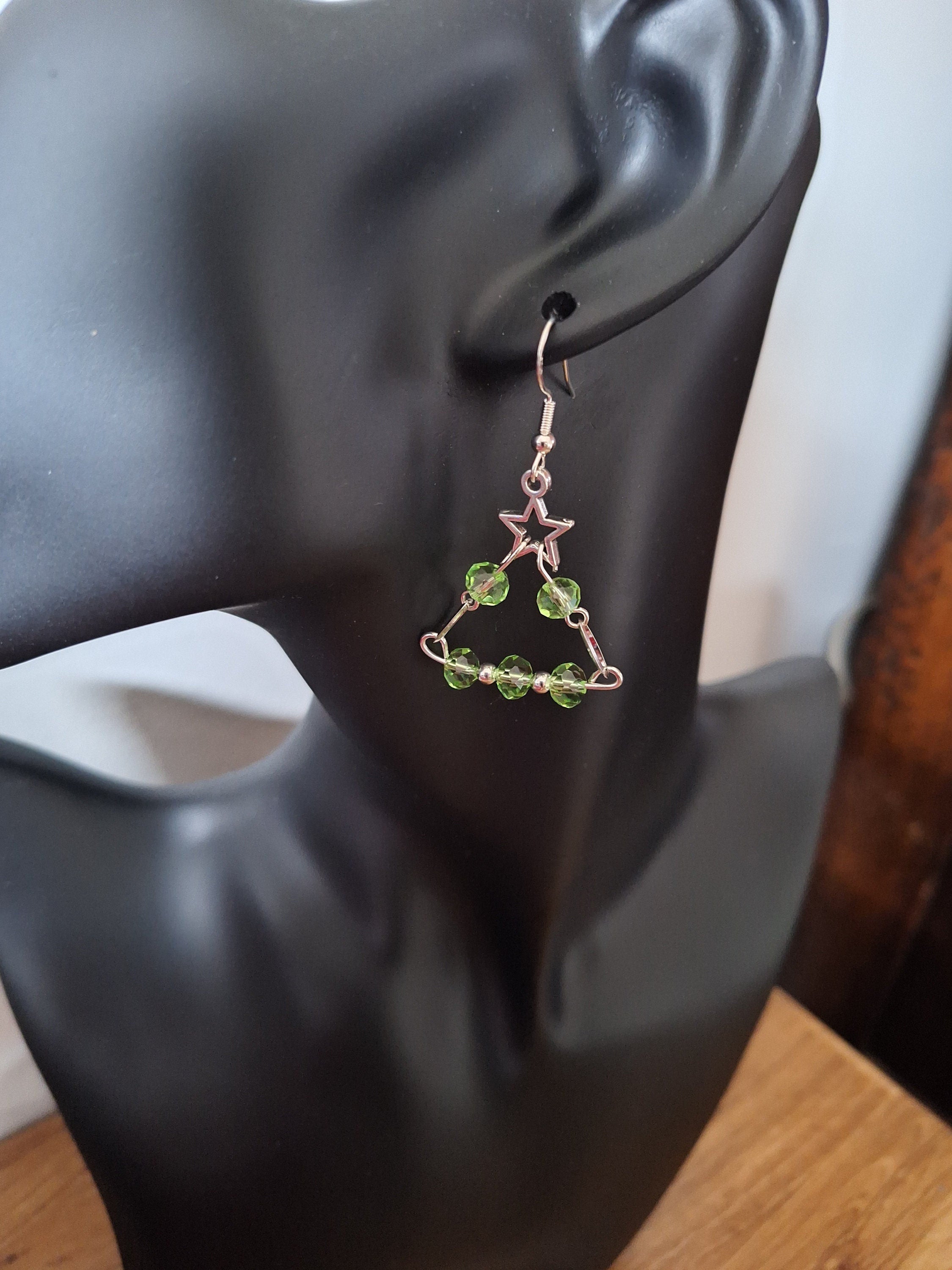 Eve Chandelier Earrings shaped like Christmas trees with green glass beads and sterling silver ear wires on a mannequin.