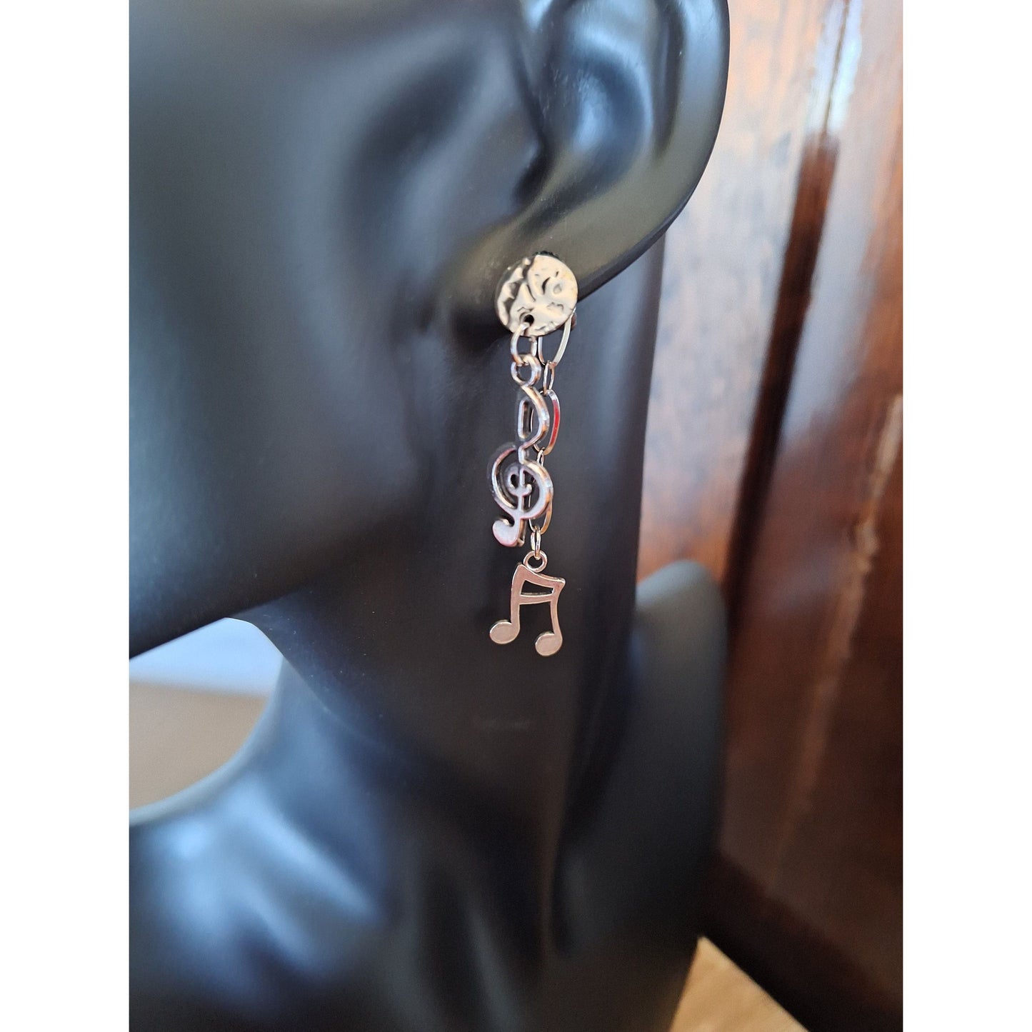 Silver earrings featuring musical notes and a treble clef