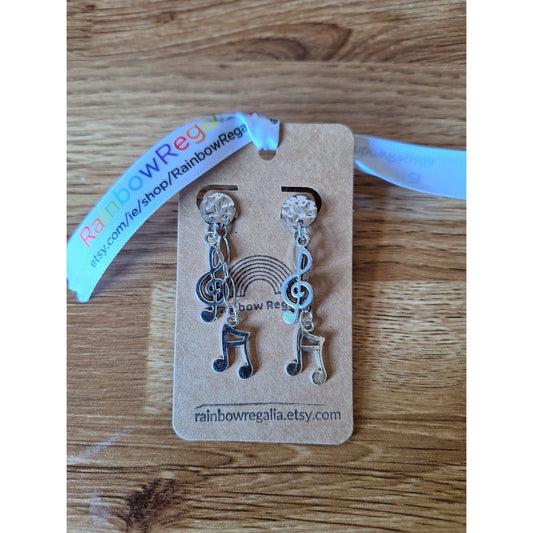 Aida Musical Chain Drop Earrings with treble clef and note charms on card.
