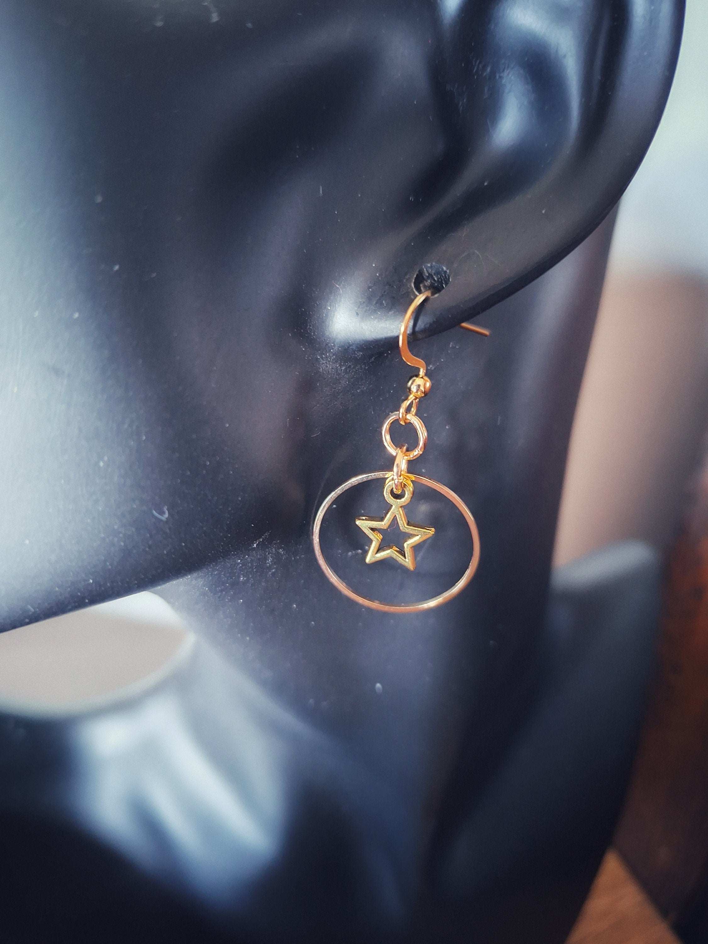 Vega Star Earrings with hollow star in a gold circle on ear.