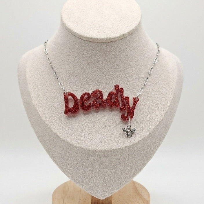 Necklace with Deadly written in red glitter with bee charm.